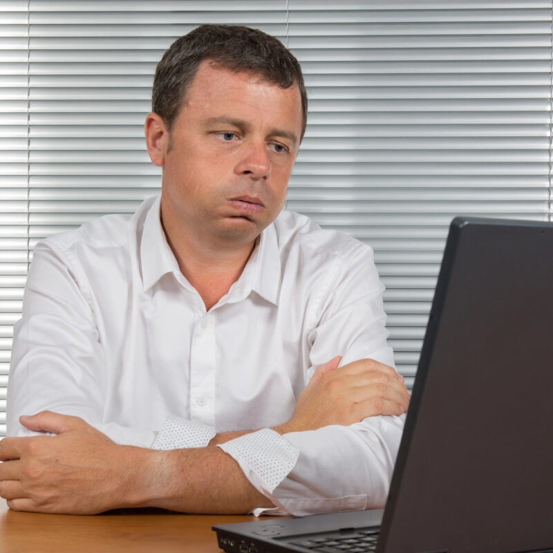 frustrated man at office looking at his system - Clearing Your Criminal Record Starts by Understanding Record Suspensions in Canada